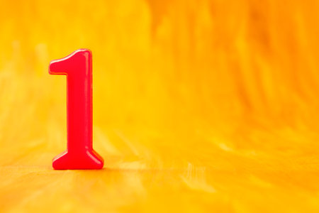 Red number one on a golden background with copyspaceの写真素材