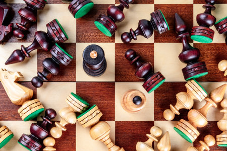 An overhead photo of a checkmate situation in chess with nearly all the pieces fallen on the...