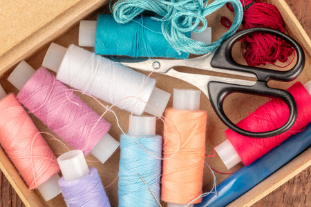 Overhead closeup photo of sewing box with threads and scissors