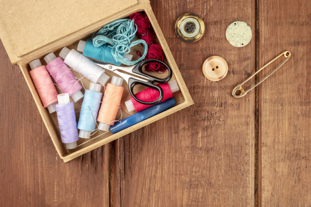 Overhead photo of sewing box with vintage pin, buttons, and copy spaceの写真素材
