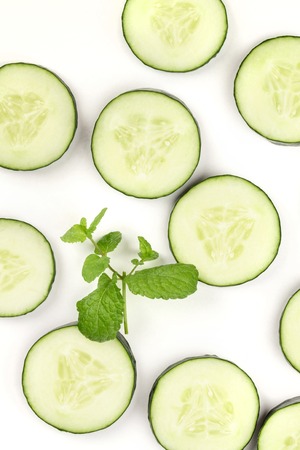 Cucumber slices and mint leaves on white, a fresh backgroundの写真素材