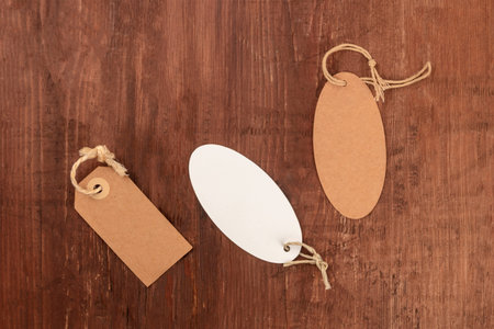 An overhead photo of a collection of brown craft paper and white labels or price tags, shot from...