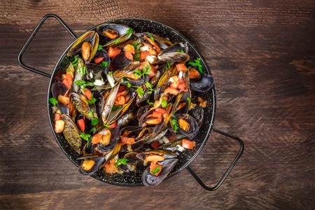 Skillet of marinara mussels on rustic background with copyspaceの写真素材