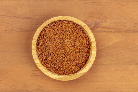 An overhead photo of a bowl of brown sugar, shot from the top on a dark rustic wooden background with copy spaceの写真素材