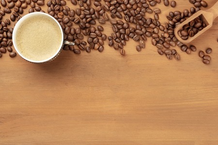 An overhead photo of coffee in a vintage cup, with coffee beans, a scoop, and copy spaceの写真素材