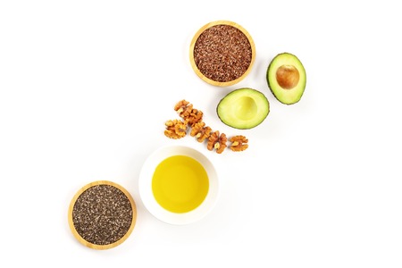 Healthy organic omega 3 vegan diet food. Avocado, nuts, chia and flax seeds, shot from above on a white background with a place for textの写真素材