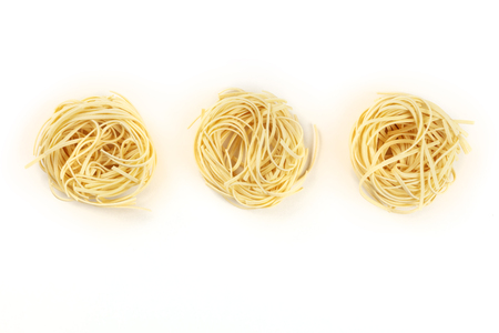 A photo of three nests of udon noodles, shot from the top on a white background with a place for textの写真素材