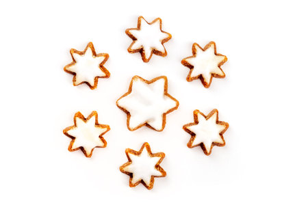 A photo of Zimsterne, traditional German cinnamon star cookies, shot from the top on a white...