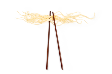 An overhead photo of chopsticks with udon noodles, shot from the top on a white background with copy spaceの写真素材