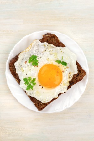 An egg cooked sunny side up on a toast, shot from above with a place for textの写真素材