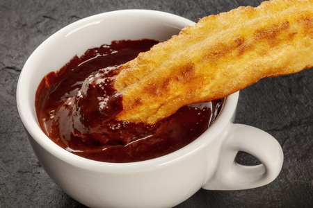 A closeup of traditional Spanish porras with hot chocolate, a typical Madrid Sunday breakfastの写真素材