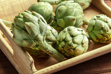A closeup of a globe artichoke in a wooden crateの写真素材