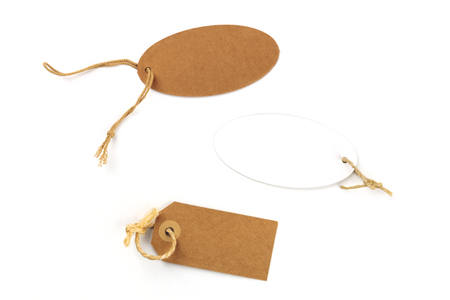Brown craft paper and white labels. Price tags shot from the top on a white background with a place for textの写真素材