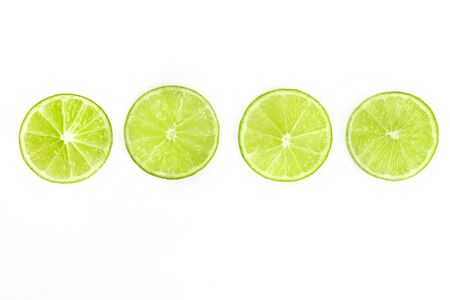 Vibrant lime slices, shot from above on a white background, a fresh fruity design element with a place for textの写真素材