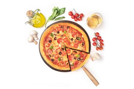 Pepperoni pizza with wine and ingredients, shot from the top on a white background with copy space. Mushrooms, olive oil, basil, tomatoes around a pizza stoneの写真素材