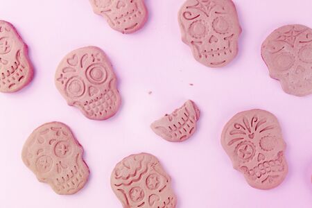Halloween greeting card with skull ginger cookies pattern, shot from the top on a pink background with a place for textの写真素材
