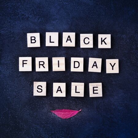 Black Friday Sale banner, a square design with a vibrant autumn leaf on a black background textureの写真素材