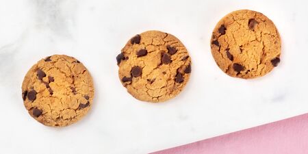 Chocolate chip cookies panorama, shot from above on a white marble and pink backgroundの写真素材
