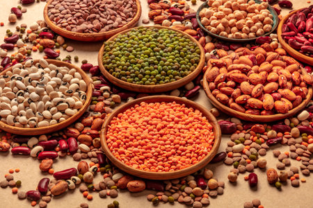 Legumes assortment on a brown background. Lentils, soybeans, chickpeas, red kidney beans, a variety...