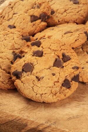 Chocolate chip cookies close-up on a rustic wooden background with a place for logo or textの写真素材