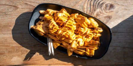 Patatas bravas, typical Spanish food. Potato with a spicy sauce, shot from the top on a wooden table