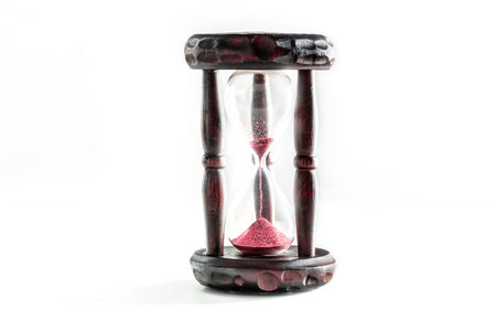 Time concept. An hourglass with sand falling through, on a white background