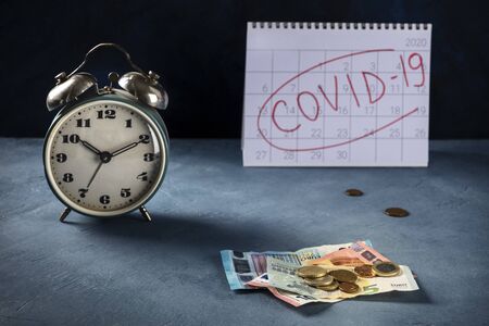 Covid-19 impact on European economy, economical consequences of the quarantine concept. A watch, monthly calendar and the last euro savingsの写真素材