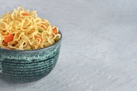 Instant noodles with carrot and scallions, vegetable soba bowl closeup with a place for textの写真素材