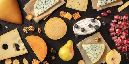 Cheese flat lay panorama. Many different cheeses, shot from above on a dark backgroundの写真素材
