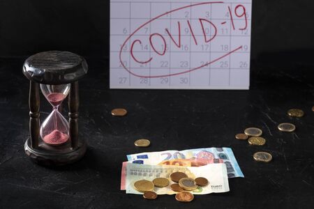 Covid 19 impact on European economy, severe economical consequences of the quarantine concept. Hourglass, monthly calendar and the last savings in eurosの写真素材
