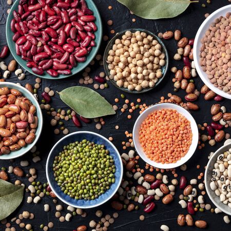 Legumes assortment, overhead square shot on a dark background. Lentils, soybeans, chickpeas, red kidney beans, a vatiety of pulsesの写真素材