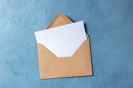 Autumn stationery mockup, overhead flat lay shot of a greeting card or invitation in a brown craft envelopeの写真素材