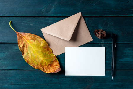 A greeting card or invitation with an envelope, an autumn stationery mockup, overhead flat lay shotの写真素材