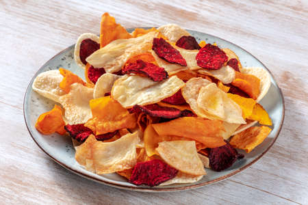 Vegetable chips on a plate, a healthy vegan snackの写真素材