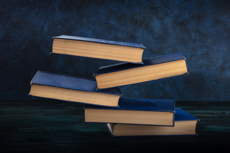 Books falling on the desk on a blue background
