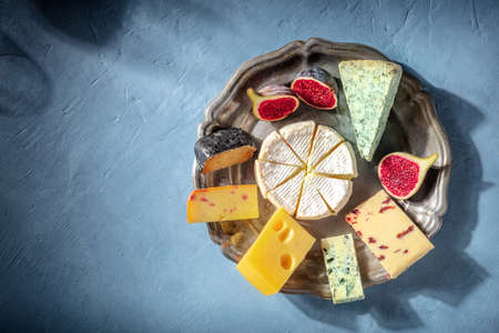 Cheese board and a silhouette of a glass of wine, top shot with a place for text. Brie, blue cheese and other varietiesの写真素材