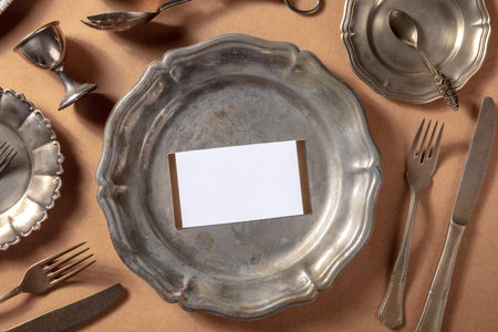 Dinner invitation mockup with an RSVP card, shot from the top on a vintage silver salver with other...