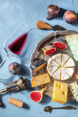 Cheese and wine, top shot. Cheese board with Brie and fruits, with a glass of red wine. Tasting and pairingの写真素材
