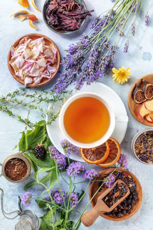 Herbal tea ingredients. Herbs, flowers, and fruit, shot from the top with a cup of tea, a flat layの写真素材