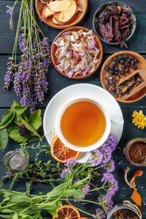 Tea with herbs, flowers and fruit, shot from the top on a dark rustic wooden backgroundの写真素材