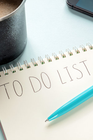 To do list concept. A paper notepad with a coffee mug and a blue pen. The concept of planning, time...