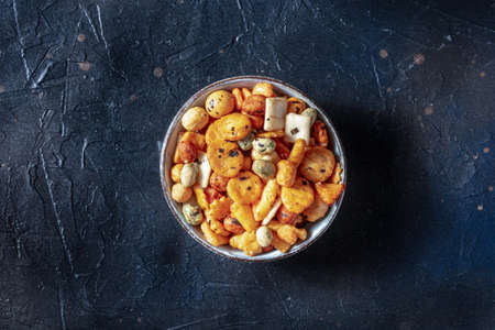 Japanese rice crackers in a bowl on a black slate background, overhead shotの写真素材