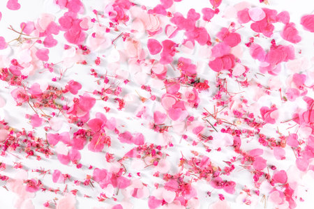 Valentine day or wedding background with paper pink hearts and rose flowers confetti, a flat lay on...