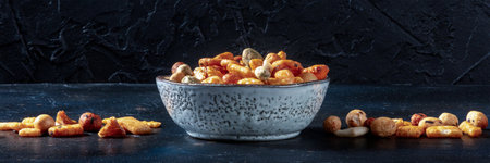 Japanese rice crackers in a bowl on a black slate background, panorama, side view with copy spaceの写真素材