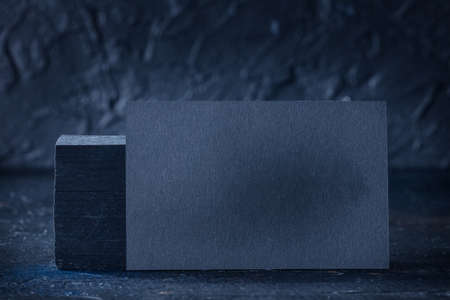 Black business card mock-up on a black slate background, a template for design presentation, thick cardboardの写真素材