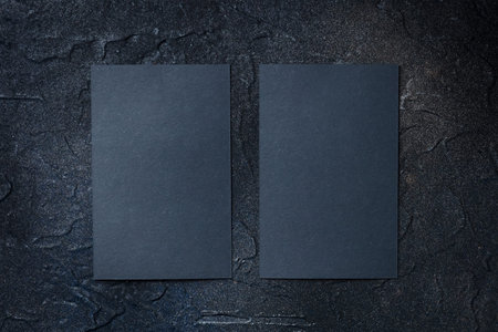 Black business cards mockup, front and back, vertical, on a dark background, a template for design...