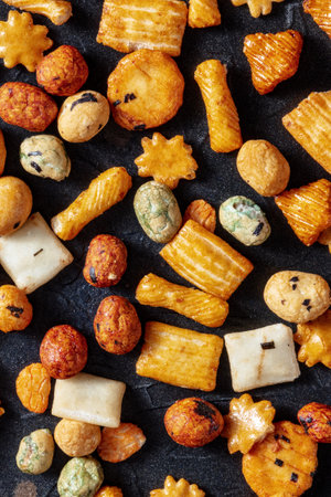 Japanese rice crackers assortment on a black slate background, top shotの写真素材