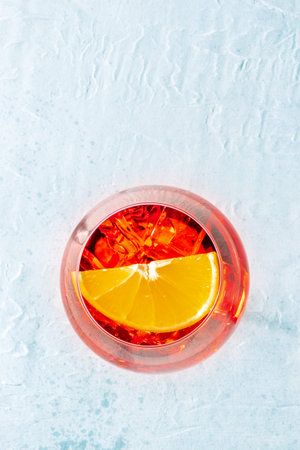 Aperol cocktail with a fresh orange slice, Italian summer cold drink, shot from above with a place...