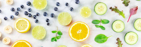 Fresh summer food panorama, fruit and vegetable salad ingredients, shot from the top on a white marble backgroundの写真素材