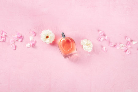Rose fragrance essence flat lay composition, shot from the top on a pink background with fresh...